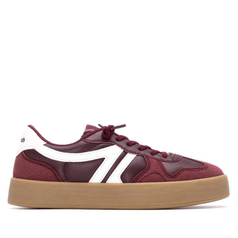 A maroon and white vegan trainer featuring a leather and suede upper, white side detailing, and a thick tan rubber sole, shown in side profile; PETA-certified and designed as non-slip footwear.