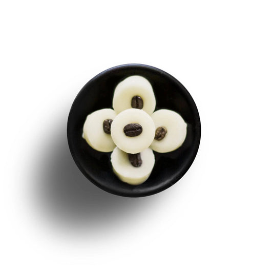 A black bowl contains five Coffee Cooler Soya Wax Melts, each embellished with a coffee bean, arranged in a flower-like pattern on a white background.