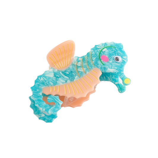 A turquoise and peach acetate hair claw shaped like a seahorse, featuring a googly eye and a textured design.