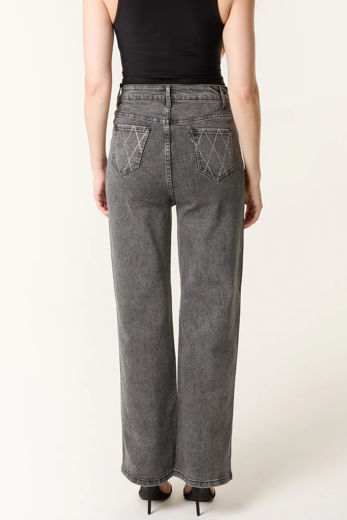 A person wearing a black sleeveless top and high-waisted, wide-leg stretch denim grey jeans with white stitching on the back pockets, seen from behind.