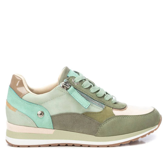 A light green and beige women’s trainer crafted from mixed materials, featuring a side zip detail, decorative stitching, a rubber sole, and credentials as vegan-friendly trainers.