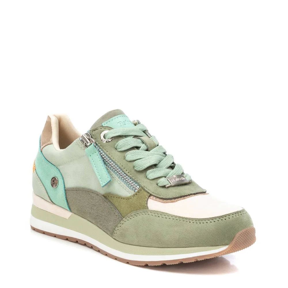 A multicoloured trainer in pastel green, mint, and cream with a side zip, white sole, and light green laces—these vegan-friendly trainers are displayed against a white background.