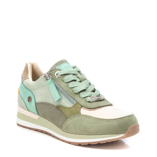 A multicoloured trainer in pastel green, mint, and cream with a side zip, white sole, and light green laces—these vegan-friendly trainers are displayed against a white background.