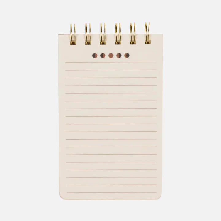A small, spiral-bound flip notebook with lined pages and five holes at the top, photographed against a plain white background.