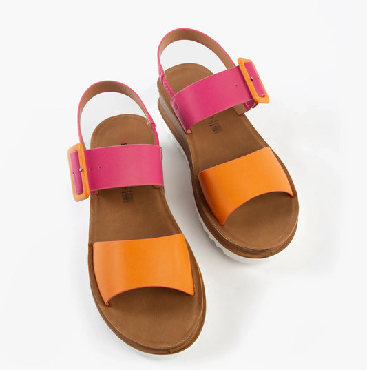 A pair of pistachio, fuchsia, and orange sandals with tan soles, wide orange toe straps, and pink ankle straps featuring large adjustable buckle fastenings for a perfect fit.