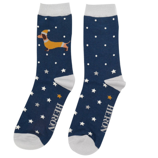 Pair of navy blue bamboo socks with white toes and cuffs, featuring a dachshund dog, white polka dots, star motifs, and the word HERON printed by the toes—ideal festive socks for any occasion.