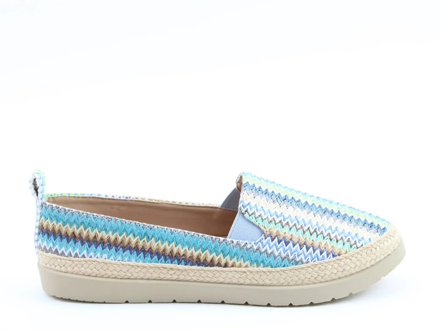 A vibrant zigzag-patterned slip-on luxury sandal with a woven sole, displayed on a plain white background. Perfectly embodying style and comfort, this Gracie Blue design is also vegan-friendly for the eco-conscious trendsetter.