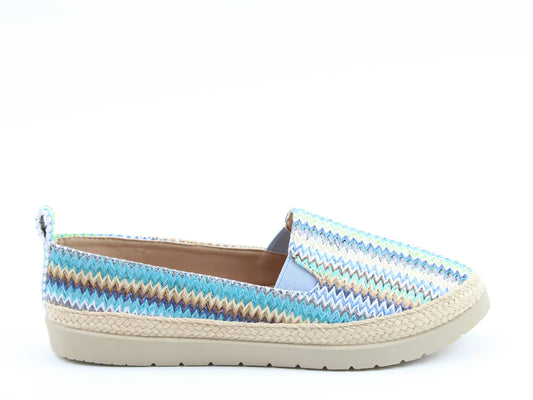 A vibrant zigzag-patterned slip-on luxury sandal with a woven sole, displayed on a plain white background. Perfectly embodying style and comfort, this Gracie Blue design is also vegan-friendly for the eco-conscious trendsetter.