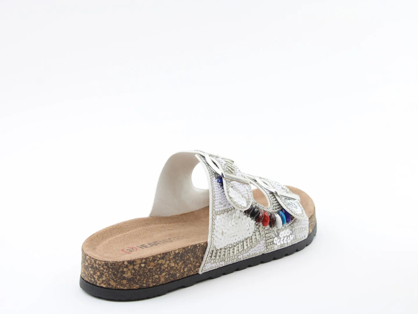 A single slip-on sandal with a cork sole, metallic silver upper, and decorative beads and sequins, crafted from vegan-friendly materials for the perfect summer look.