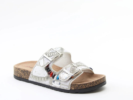 A single slip-on White Sequin Sandal features two silver-buckled straps, a cork footbed, a textured white upper, and multicoloured bead accents—crafted from vegan-friendly materials for a chic summer look.