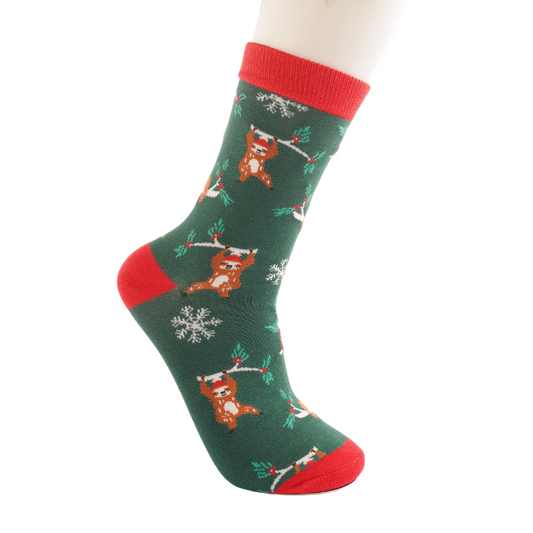 Green sock with red toe, heel, and cuff, featuring a festive pattern of foxes, snowflakes and holly branches—these Christmas socks are shown on a mannequin foot.