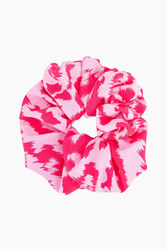 Pink and white patterned fabric scrunchie featuring an abstract, jagged design, shown against a plain white background.