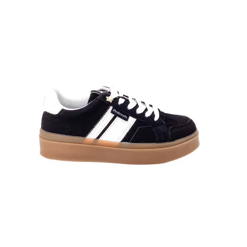 A pair of black trainers with white laces, white side stripes, a branded tag and a thick brown rubber sole is displayed on a white background—ideal cruelty-free trainers for everyday wear.