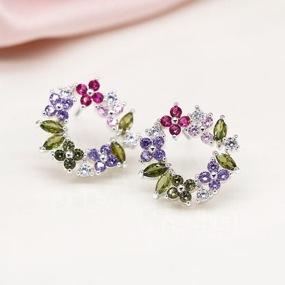 Floral Circle Studs with colourful wreath designs, featuring pink, purple, and green gemstones set in faceted crystals. These silver-plated earrings gleam beautifully against a white background.