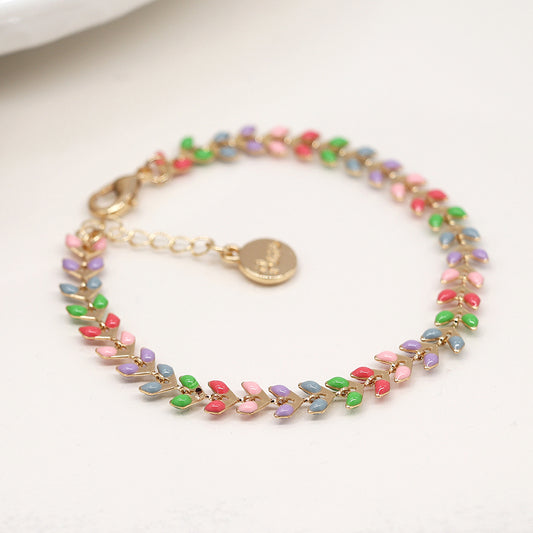 The Golden Pastel Epoxy Droplets Bracelet is a luxurious accessory featuring a gold chain with colourful leaf-shaped links in pink, red, green, purple, and blue. Its sophisticated design includes a lobster clasp and a circular charm.