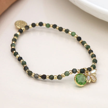 A Green & Gold Bracelet adorned with a faux gold-plated bee charm, shimmering with green and gold beads and a striking green gemstone pendant.