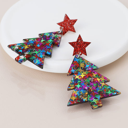 A pair of Christmas Tree Earrings with multicolour star patterns and red glittery star studs, displayed on a white dish—perfect festive jewellery to brighten up your holiday look.