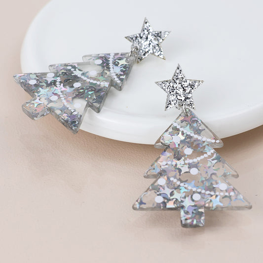 A pair of glittery acrylic Christmas tree earrings with star tops, embellished with silver and iridescent sequins, shown on a white surface—ideal festive jewellery for the holiday season.