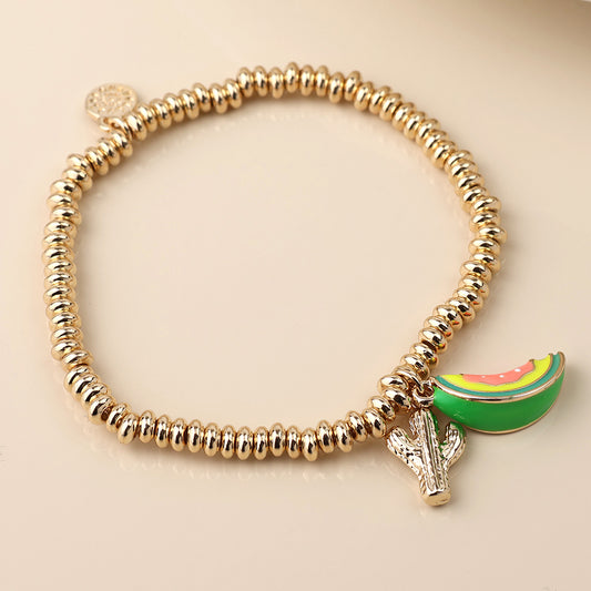 A gold beaded charm bracelet featuring two quirky charms: a green and pink watermelon slice and a small silver cactus—perfect statement jewellery for anyone with a fun-loving style.