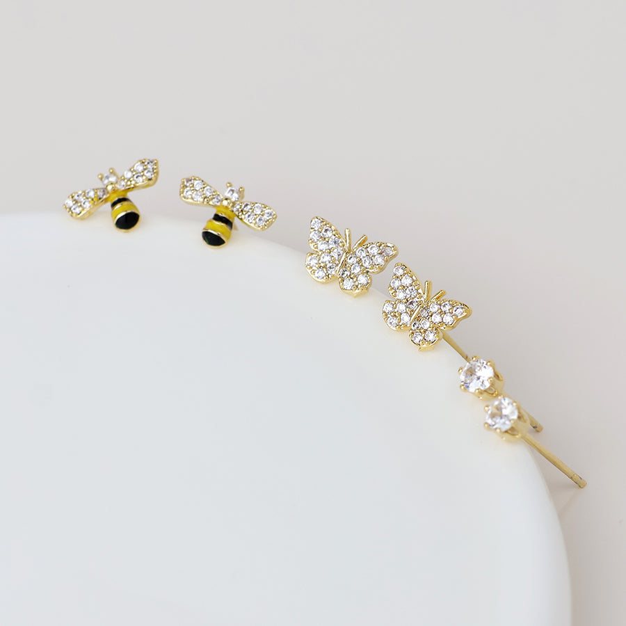 Three pairs of gold stud earrings are shown: one pair with bees, another with butterflies, and the third featuring round crystal studs.