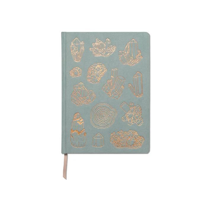 A light green, eco-friendly notebook with gold-foil crystal designs on the cover, lined pages, and a beige ribbon page marker.