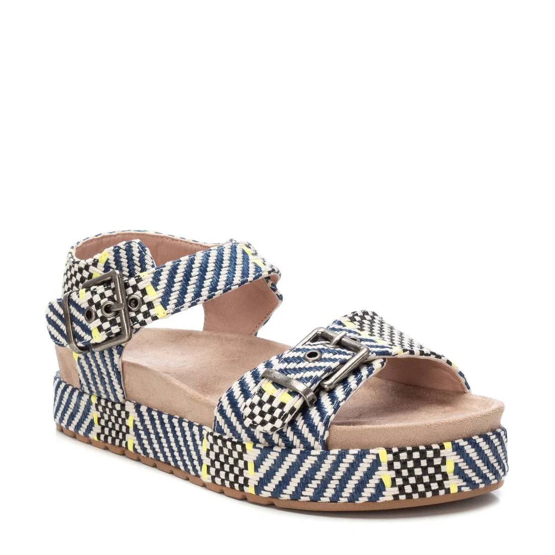 A navy platform beach sandal featuring blue, black, white, and yellow chequered fabric straps, two metallic buckles, a cushioned beige footbed, and a stylish platform sole.