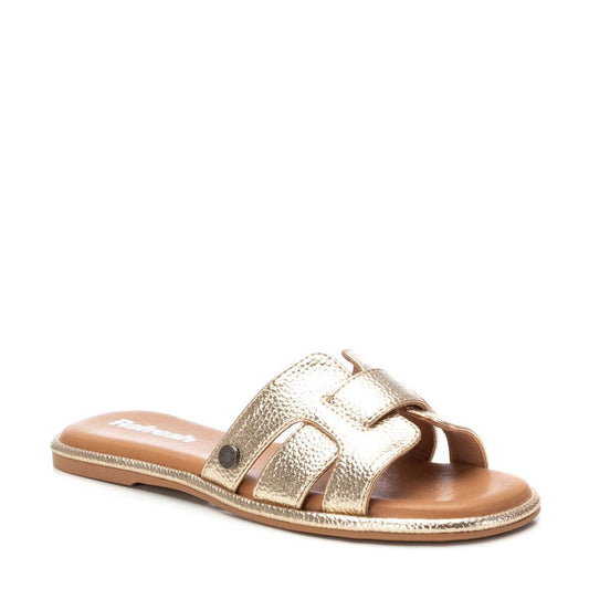 A single gold metallic slide sandal with an open toe, flat sole, and wide woven strap, displayed against a white background—perfect for those seeking stylish gold womens sandals.