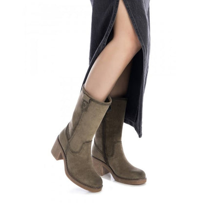 A person wearing khaki vegan faux suede boots with a block heel and a black skirt featuring a front slit, embracing cruelty-free fashion.