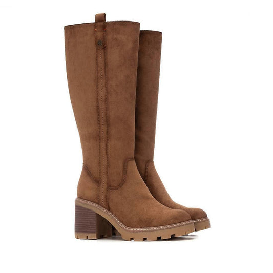 A pair of taupe faux suede, vegan-friendly knee-high boots with block heels, side stitching, and lugged rubber soles, displayed against a white background.