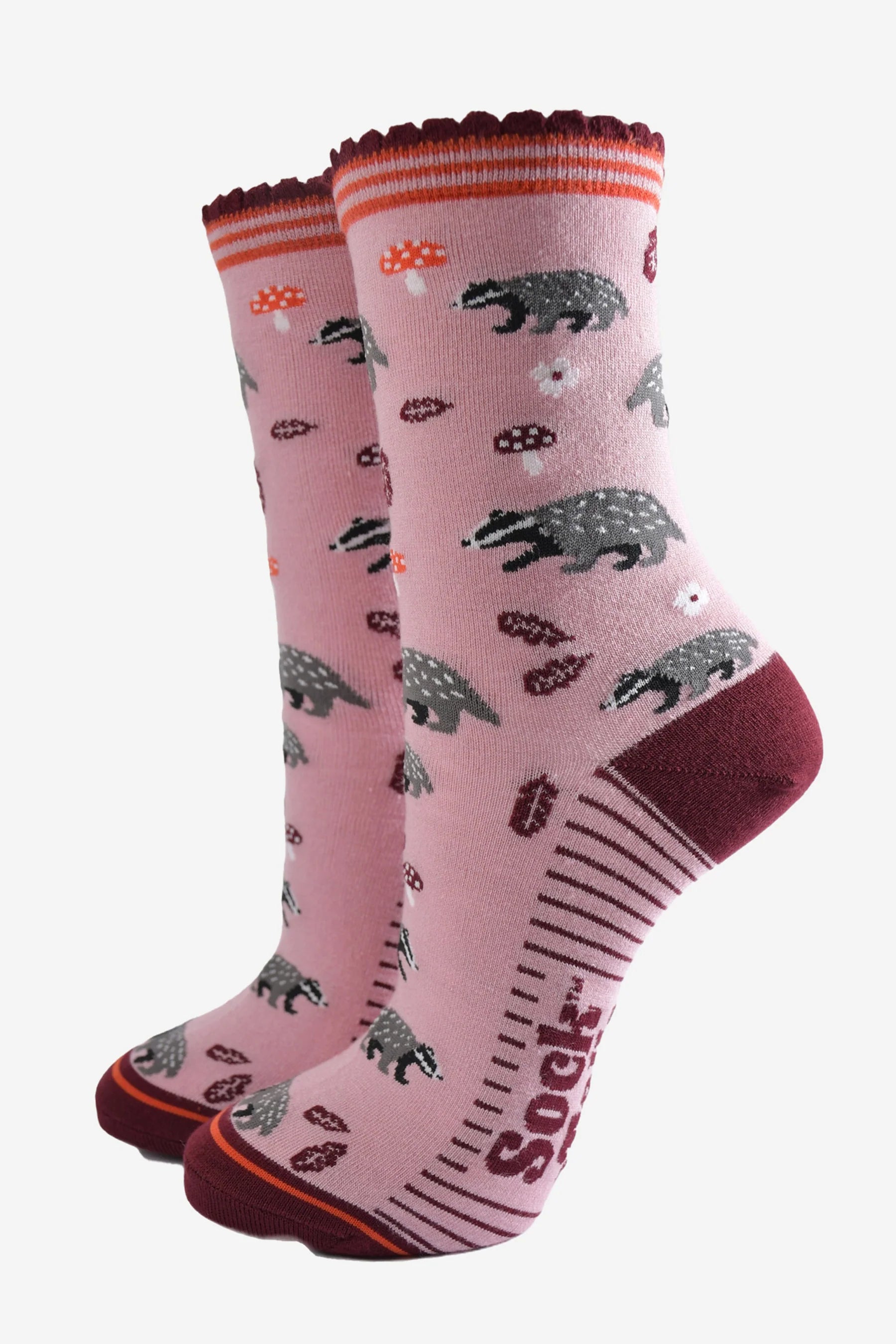 Vegan Badger Pink Socks with badgers, mushrooms, paw prints, and maroon accents—an eco-friendly fashion statement with "Socks" on the sole.