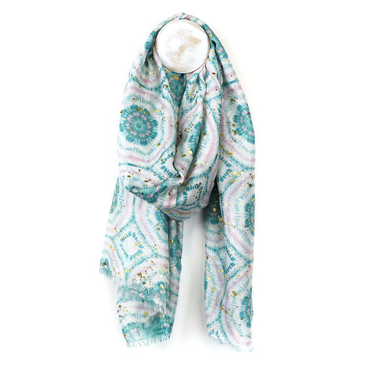 A light blue and white patterned summer scarf featuring geometric designs is draped over a round white hook against a white background.