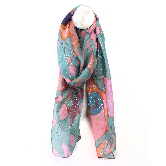 A luxurious scarf drapes elegantly on a white mannequin head, featuring abstract butterfly wing designs in vibrant pink, teal, and orange tones.