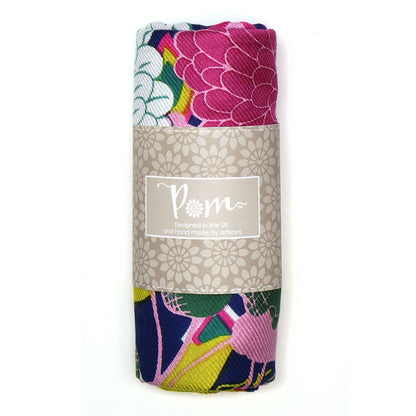 A multi-print design decorates this rolled fabric, wrapped in branded paper and featuring a colourful floral pattern in pink, blue, green, and white—perfect for the fashion enthusiast.