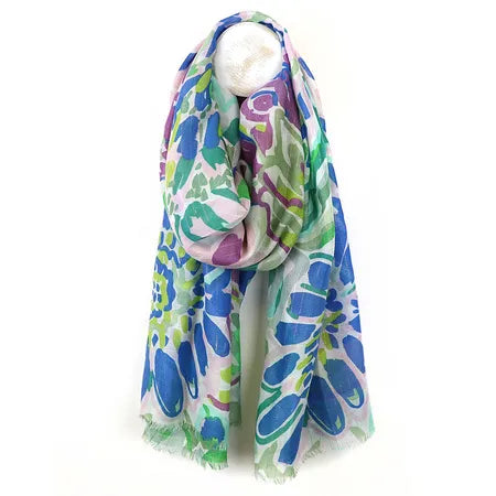 A lightweight blue-mix summer scarf featuring a colourful floral pattern in green and purple, shown draped over a white mannequin—ideal as a stylish beach cover-up.