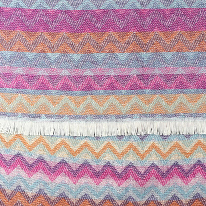 Colourful chevron scarf with zigzag patterns in purple, blue, orange and pink shades, featuring a white fringe along one edge.