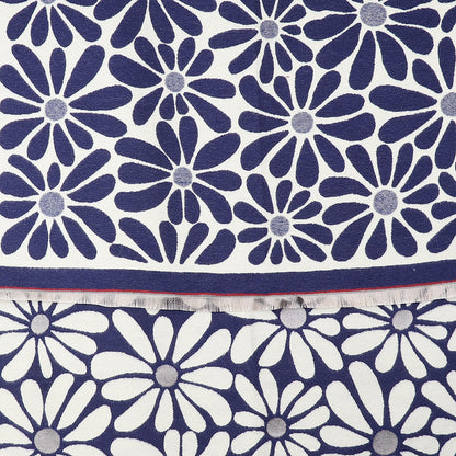 A close-up of fabric displaying a navy blue and white daisy motif, with overlapping floral patterns and a visible edge showing frayed threads—ideal for a Navy Retro Daisy Scarf.