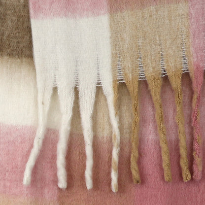 Close-up of a pale pink chunky checked scarf with twisted fringe, crafted from soft wool in blocks of white, beige, and pink.