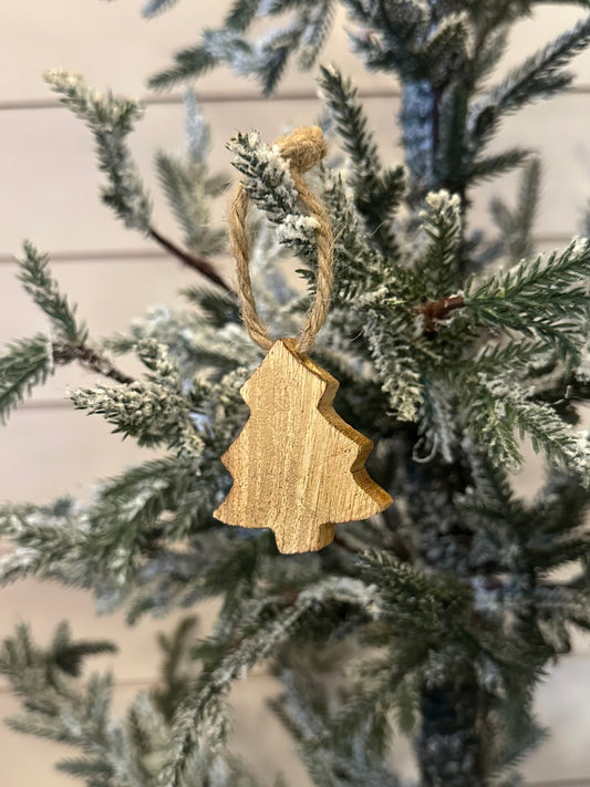 A small, gold wooden Christmas tree decoration hangs from a snow-dusted artificial pine branch, lending rustic festive charm to your celebrations.