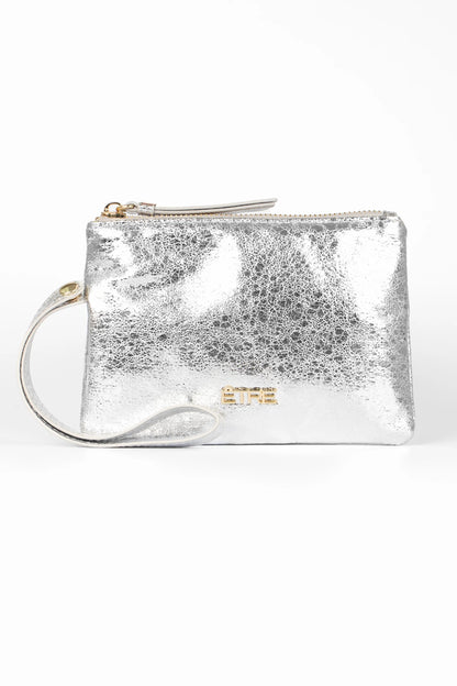 Small metallic faux leather wristlet purse with zip fastening, wrist strap, and gold-tone logo detail on the front, photographed against a white background. This stylish accessory is both chic and vegan-friendly.