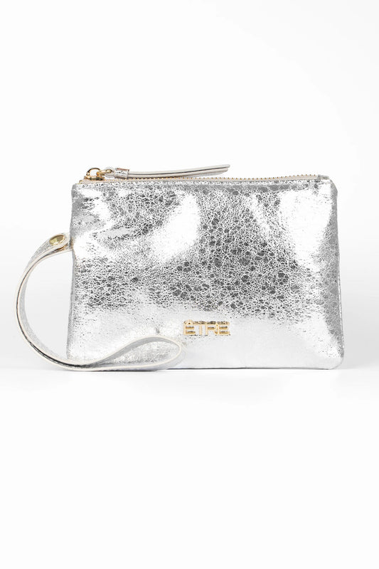 Small metallic faux leather wristlet purse with zip fastening, wrist strap, and gold-tone logo detail on the front, photographed against a white background. This stylish accessory is both chic and vegan-friendly.