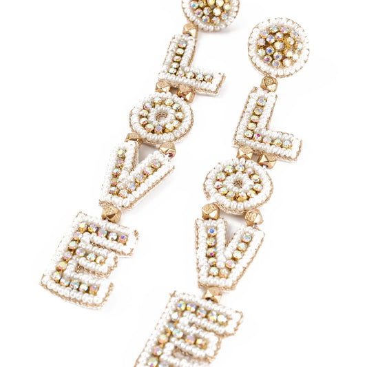Pearl Glitzy Love Drop Earrings with gold and silver beads spell LOVE in a vertical arrangement, making these unique, handmade earrings a dazzling addition to any collection.