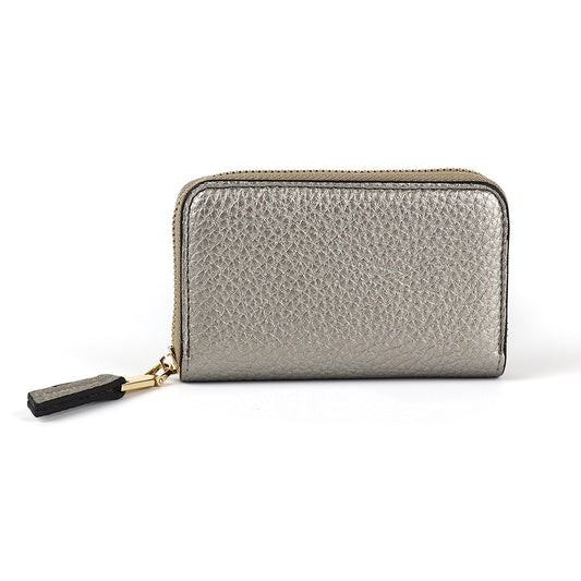 A luxurious silver zipped wallet, crafted from metallic faux leather with a textured surface and a dark pull tab, elegantly positioned against a plain white background.