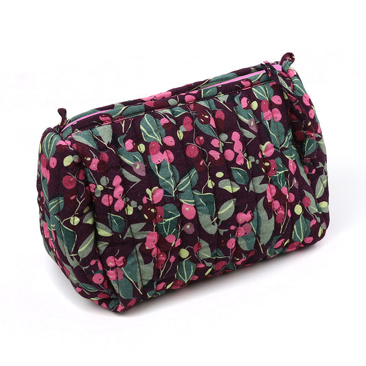 A quilted make-up bag with a zip, showcasing a deep purple background adorned with a green and pink floral design—ideal for keeping your beauty essentials. Presenting the delightful Winter Berry Quilted Make-up Bag.