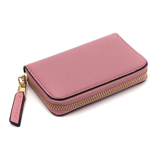 A small pink leather zippered wallet with a gold zip and matching pull tab, designed to complement your favourite quilted makeup bag, set against a white background.