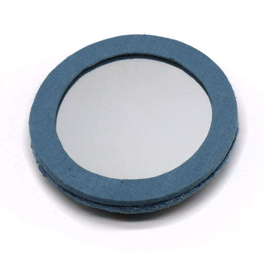 A circular compact mirror with velvet embroidery and a blue fabric-covered frame, lying flat on a white surface—an elegant embroidered accessory for your daily essentials.