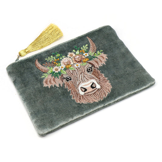 Grey velvet zip purse featuring an embroidered floral cow design and a gold tassel zip pull, displayed on a white background.