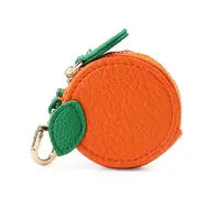 Round orange faux leather mini purse shaped like a fruit, featuring a green leaf detail, gold clasp, and convenient keyring clip.