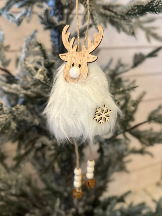 A hanging deer Christmas tree ornament with a wooden reindeer head, white faux fur body, bead legs, and a snowflake detail, ideal for festive décor on snow-dusted branches.