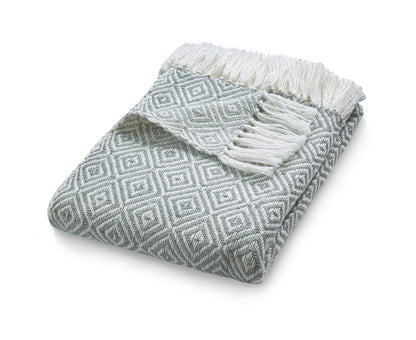 Folded grey and white sustainable throw blanket, woven from recycled plastic bottles with a geometric diamond pattern and fringed edges, placed on a white background.