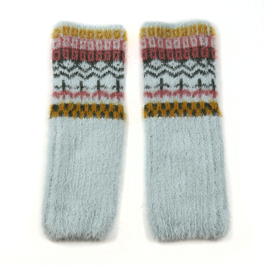 A pair of fluffy, light grey wool socks with a cosy multi-pattern design in mustard yellow, pink, and dark grey near the top, laid flat on a white background.